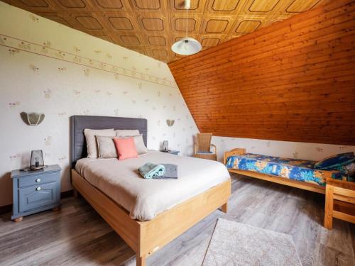 a bedroom with a large bed and a wooden ceiling at Le Cheval Blanc in Ruederbach