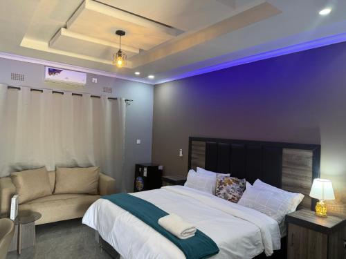 a bedroom with a large bed and a couch at Chaniche Executive Lodge in Ndola