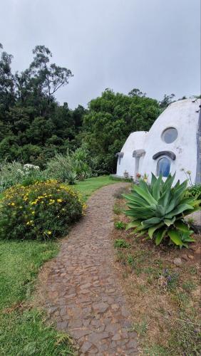 a cobblestone path leading to a dome shaped house at Arambha ecovillage farmstay in Tábua