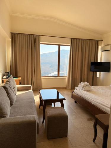 a hotel room with a couch and a bed and a window at Lastiver Resort in Yenokavan
