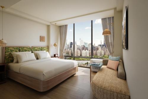 a hotel room with a bed and a large window at Z NYC Hotel in Queens
