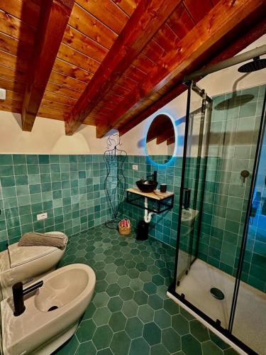a bathroom with a toilet and a sink and a shower at Agriturismo Yucca in Giustenice