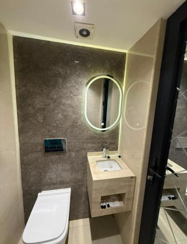 a bathroom with a toilet and a sink and a mirror at فندق وفادة الزهراء in Baghdād