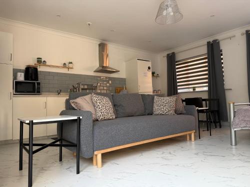 a living room with a couch and a table at The Hideaway - Secluded Studio Annexe in Cambourne