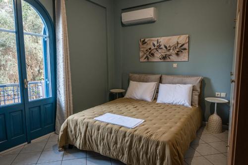 a bedroom with a bed and a blue door at Myrovolos Guesthouse in Apolpaina
