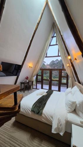 a bedroom with a canopy bed with a window at Mvubu Falls Lodge in Lobamba
