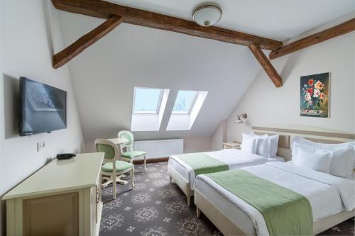 a hotel room with two beds and a tv at Hotel Leul de Aur in Sebeş
