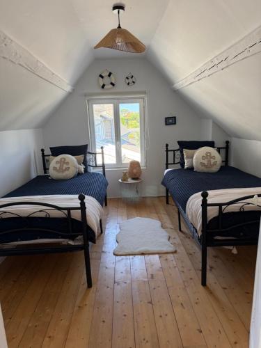 a bedroom with two beds and a window at Gîte le clos Normand in Saint-Jouin-Bruneval