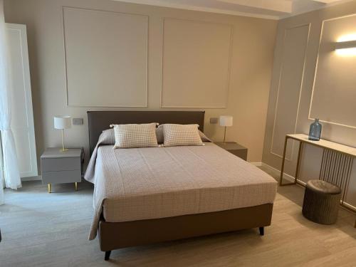a bedroom with a bed with two tables and two lamps at Residenza Isotta in Rimini