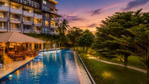 a hotel with a swimming pool in front of a building at The Par Phuket Hotel in Kathu