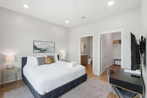 a bedroom with a bed and a desk with a television at Illume 303 in Nashville