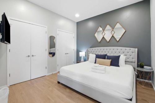 a bedroom with a large white bed and a tv at Illume 303 in Nashville