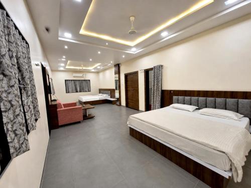 a bedroom with a bed and a chair in a room at Hotel Keshar Palace Shani Shingnapur in Sonai