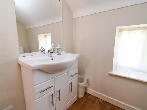 a bathroom with a white sink and a window at Pen Y Grisiau in Mold