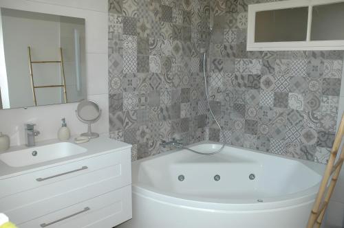a bathroom with a white tub and a sink at Cabesthotes in Cabestany
