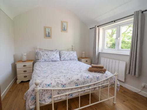 a bedroom with a white bed and a window at Ty Haf in Mold
