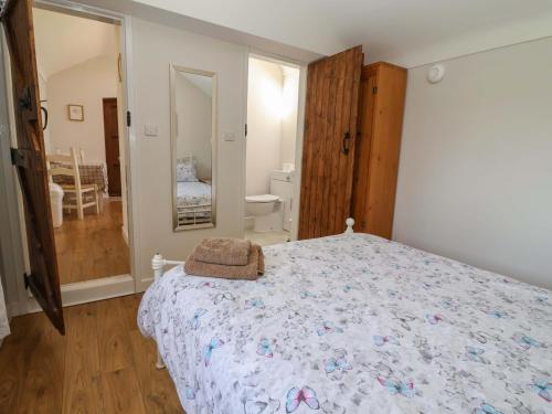 a bedroom with a large bed and a bathroom at Ty Haf in Mold