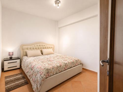 a small bedroom with a bed and a night stand at B&B ADU Civitavecchia in Civitavecchia