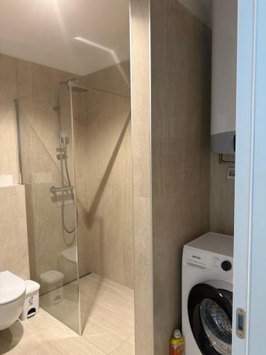 a bathroom with a shower and a washing machine at Baden Resort Bašanija, Umag-with Sea View, Parking and 300m from the beach in Bašanija
