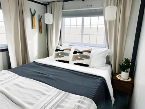 a bedroom with a bed with pillows and a window at Box Villages Pecos in Pecos
