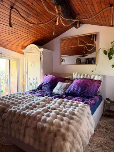 a large bed in a bedroom with a wooden ceiling at Le Château de Soleil in Saint-Pons-de-Mauchiens