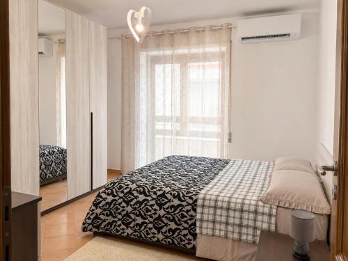 a bedroom with a bed with a black and white blanket at B&B ADU Civitavecchia in Civitavecchia
