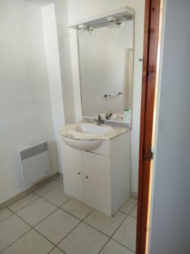 a white bathroom with a sink and a mirror at Soleiou in Salavas