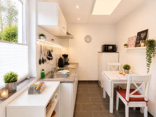 a kitchen with a sink and a table at Schwedenglück - Wald-Auszeit für 2 in Dahlen