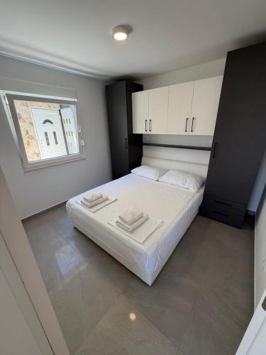 a bedroom with a bed with white cabinets and a window at Villa Omazic in Trogir