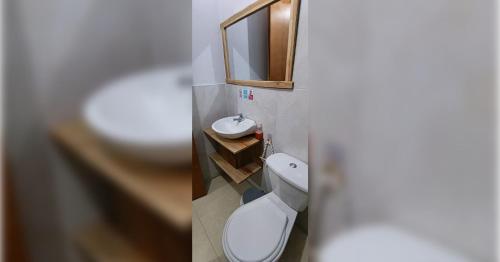 a bathroom with a white toilet and a sink at Casa MACONDO BEACH HOUSE in Rincón