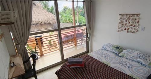 a bedroom with a bed and a large window at Casa MACONDO BEACH HOUSE in Rincón