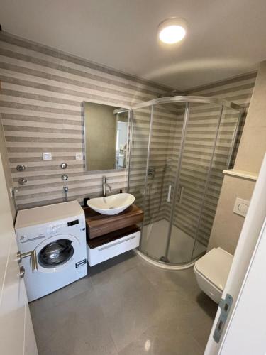 a bathroom with a sink and a washing machine at Villa Omazic in Trogir