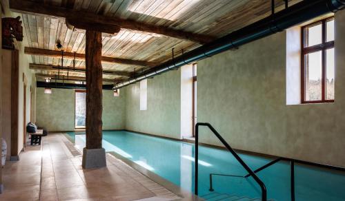 a swimming pool in a building with a ceiling at Domaine de Locguénolé & Spa - Relais & Chateaux in Kervignac