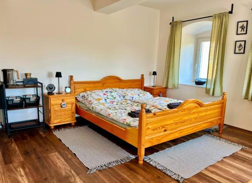 a bedroom with a wooden bed and a wooden floor at Statek Soví Dvůr in Rabyně