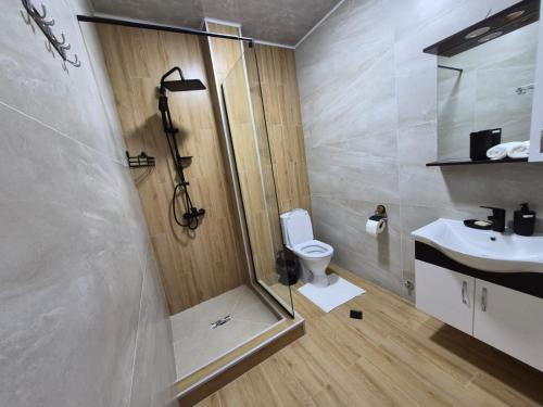 a bathroom with a shower and a toilet and a sink at Hillside House Overlooking Batumi in Charnali