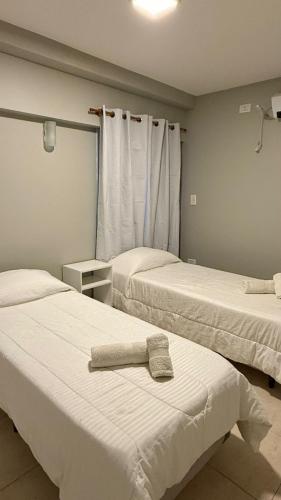 two beds in a room with a towel on the bed at Fran hotel boutique in Mendoza