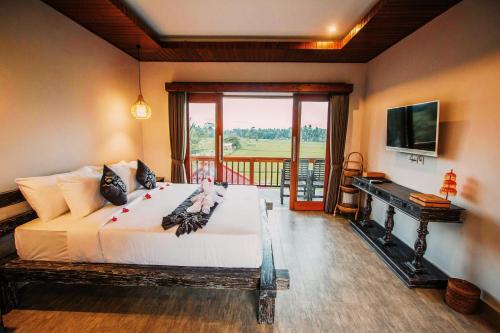 a bedroom with a large bed and a balcony at Villa Silas Ubud Bali in Ubud