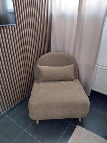 a chair with a pillow on top of it at Boom Station & Schorre Suites in Boom