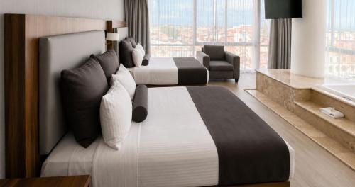 a hotel room with two beds and a chair at Panorama in San Luis Potosí