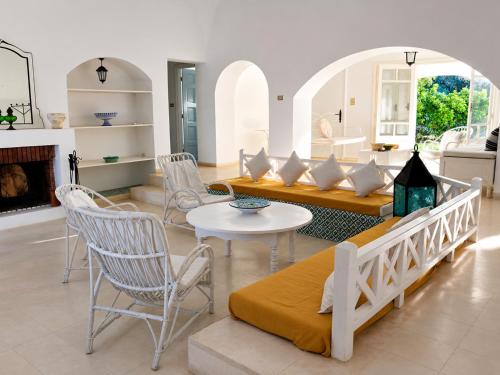a living room with a couch and a table and chairs at Maison de la Mer in Ḩammām al Ghazzāz