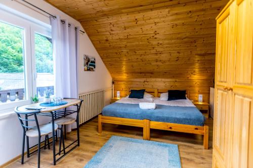 a bedroom with a bed and a table and chairs at Fakanalas Fogadó in Pásztó
