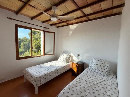 a bedroom with two beds and a ceiling fan at Tramuntana Sunset in Port de Soller