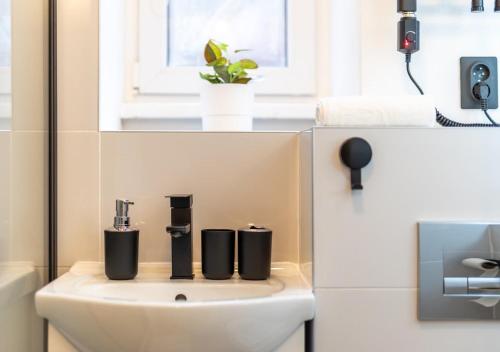 a bathroom with a sink with three bottles on it at Calm Center Modern Apartment in Staré Mesto