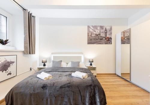 a bedroom with a large bed with white walls at Calm Center Modern Apartment in Staré Mesto