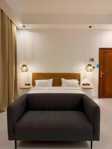 a bedroom with a large bed and a couch at Coral by Ivory Hotels in Mombasa