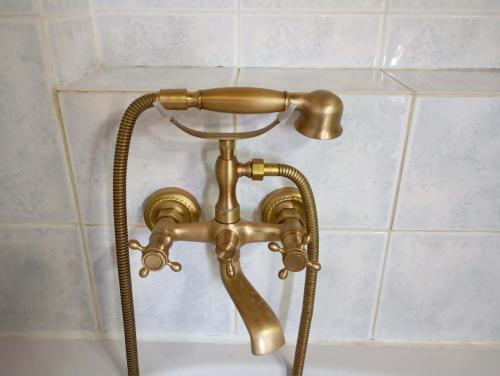 a brass shower faucet in a bathroom at villa vitta - bellissimo villagio in Kastrákion