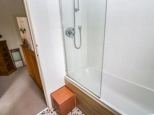 a bathroom with a shower with a tub at Snowdrop Cottage in Keighley
