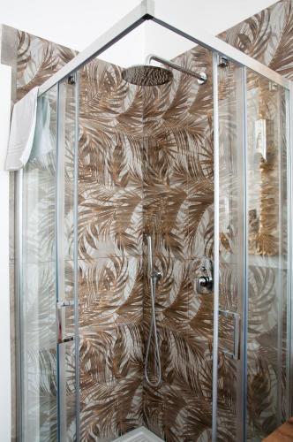 a shower in a bathroom with a wooden wall at ARENA D'INTORNO LUXURY e SUITES in Verona