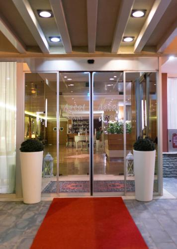 a lobby with glass doors and a red carpet at Hotel Ascot & Spa in Rimini