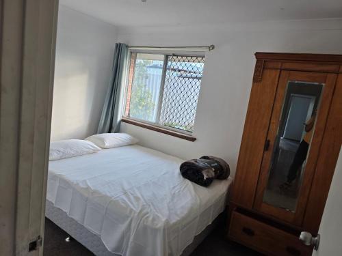 ein kleines Schlafzimmer mit einem Bett und einem Fenster in der Unterkunft Wattle Close - Room in a Shared house in Kelmscott